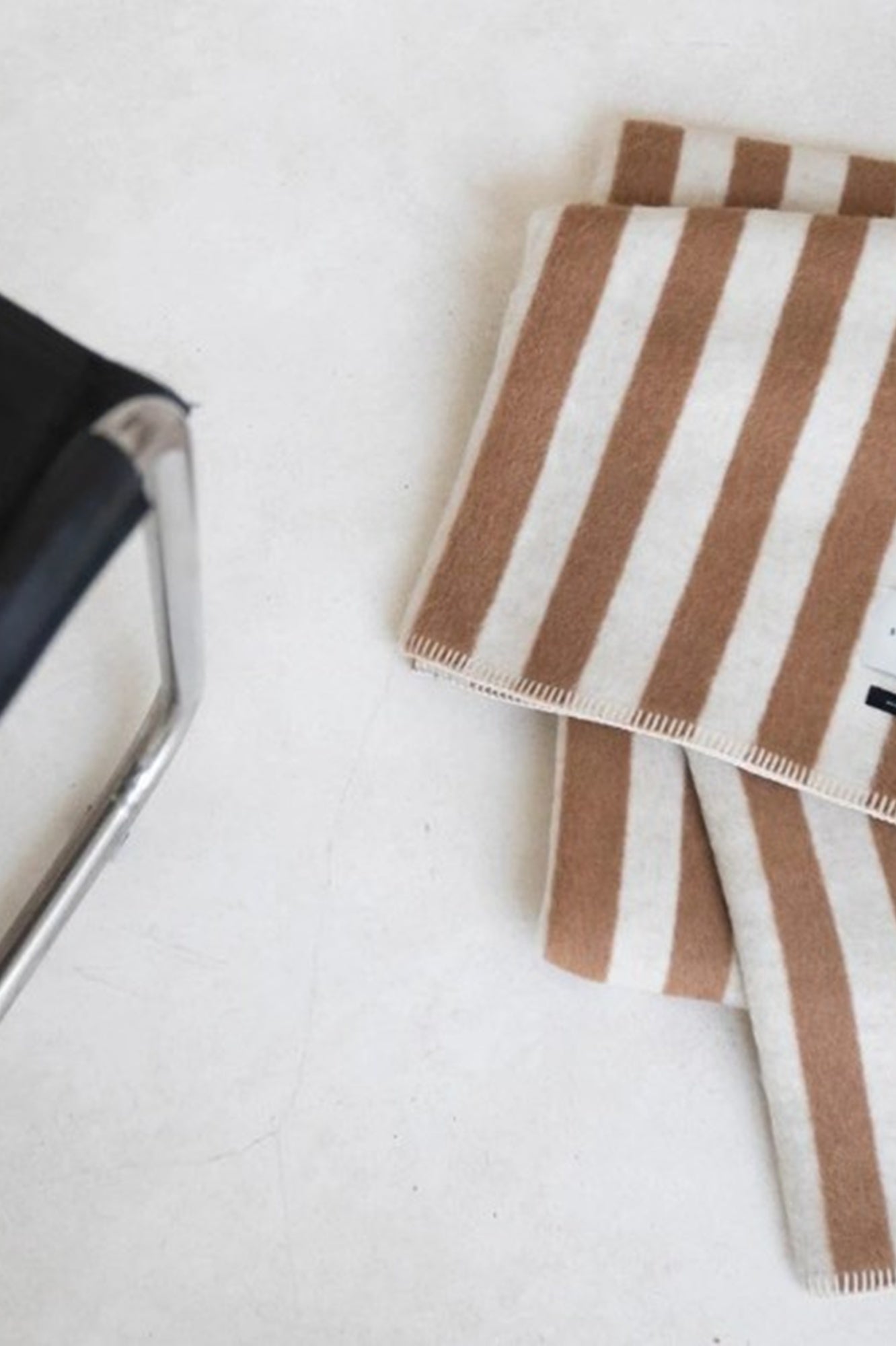 Brown and white striped fabric with a brush on a light gray background