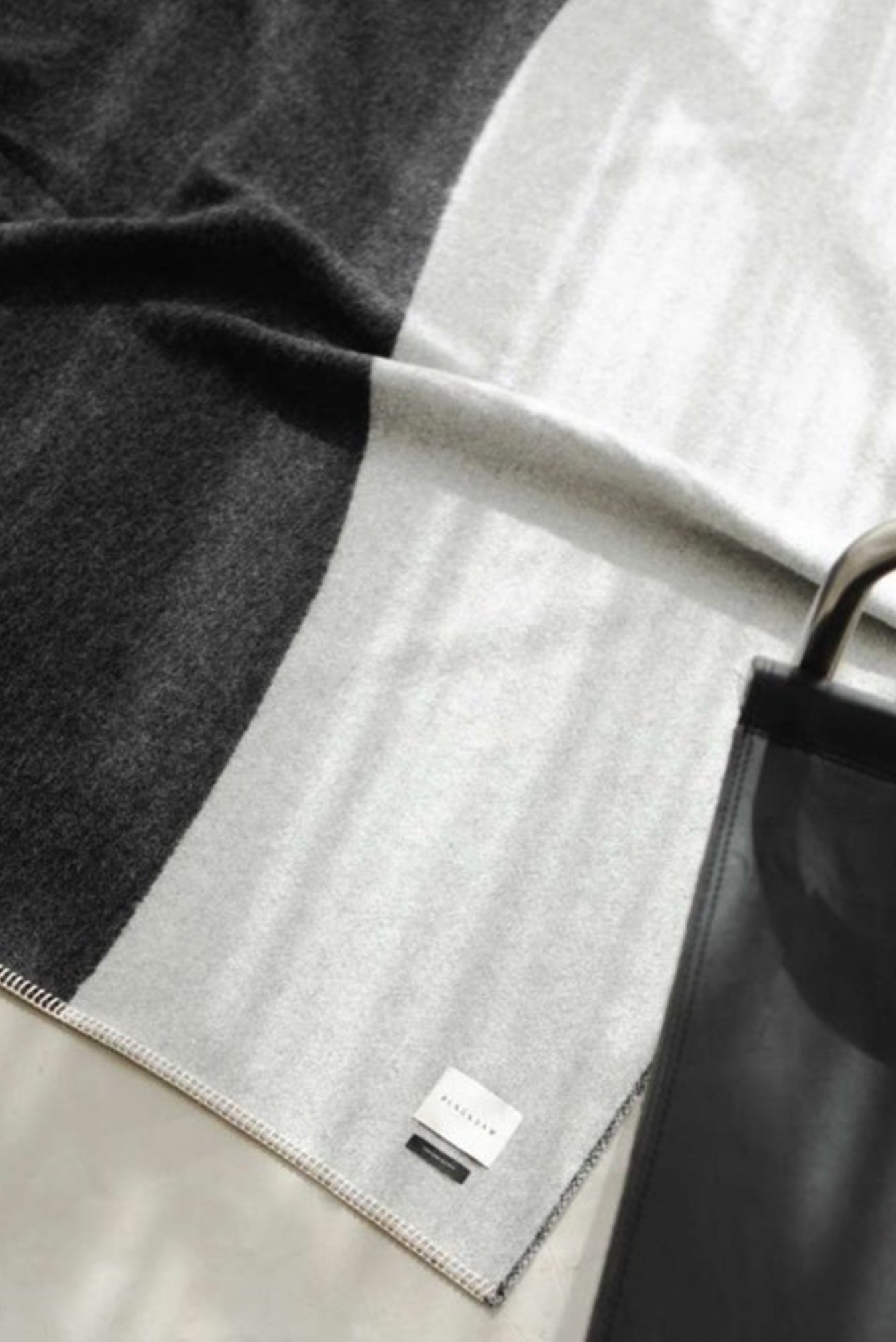 Gray fabric with a brand label draped over a surface