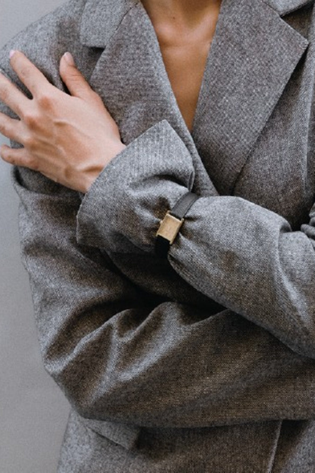 Gray coat with a button detail on a plain background