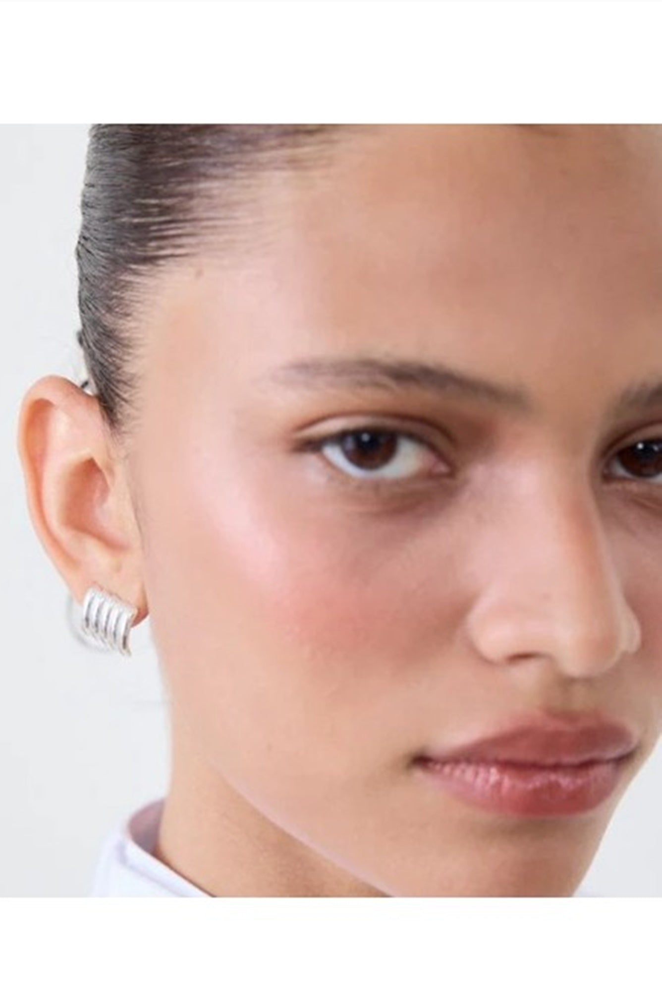 Close-up of a person's face with a neutral expression on a white background