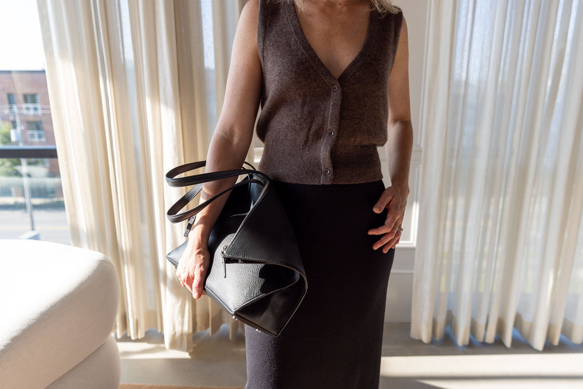 Lisa Yang Charlotta Skirt with the Eterne Leroy knit vest, carrying the black Aesther Ekme foldover bag