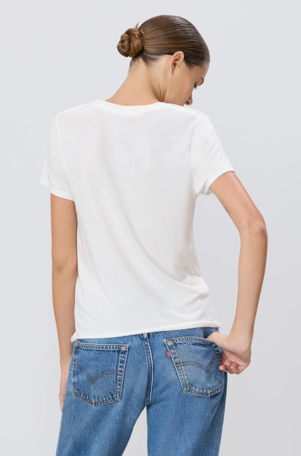 Woman wearing a white t-shirt and blue jeans on a light gray background