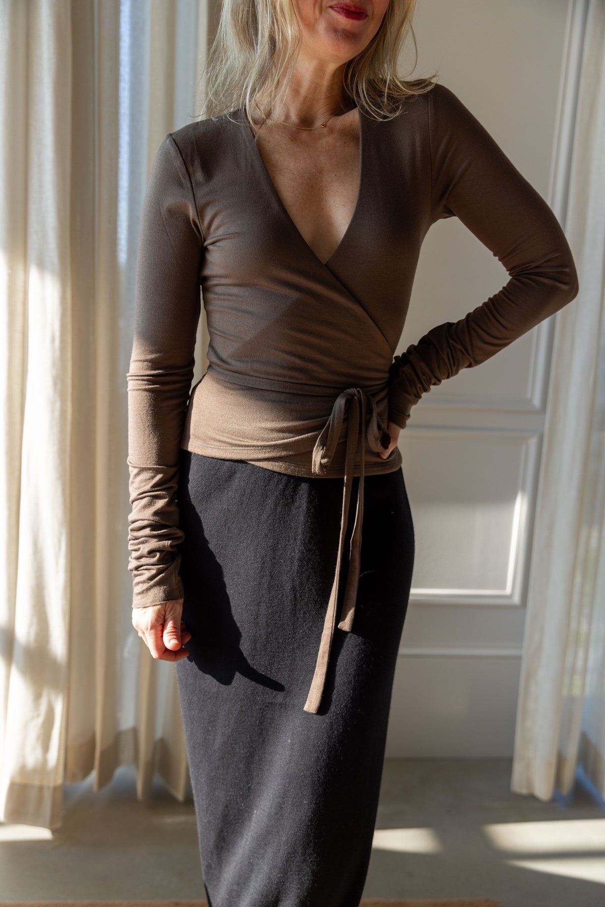 Close-up of the Eterne wrap top tied over the Lisa Yang Charlotta Skirt in fine cotton cashmere knit