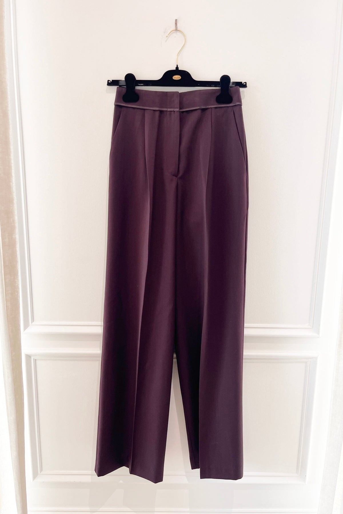 Forte Forte Grain de Poudre High Waist Pants in Bordeaux, tailored straight-leg trousers with pressed front pleats and satin trim on a hanger