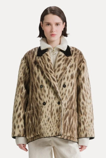 Model wearing the Forte Forte Royal Leopard Jacquard Double Breasted Coat in Giallo Oro, buttoned with a black collar, close front view
