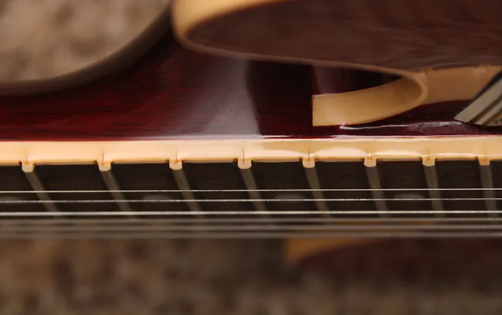 Close-up of a guitar's neck and strings with a blurred background