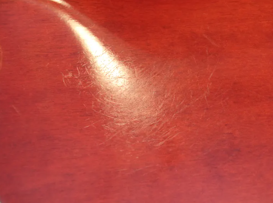 Close-up of a red textured surface with a light reflection