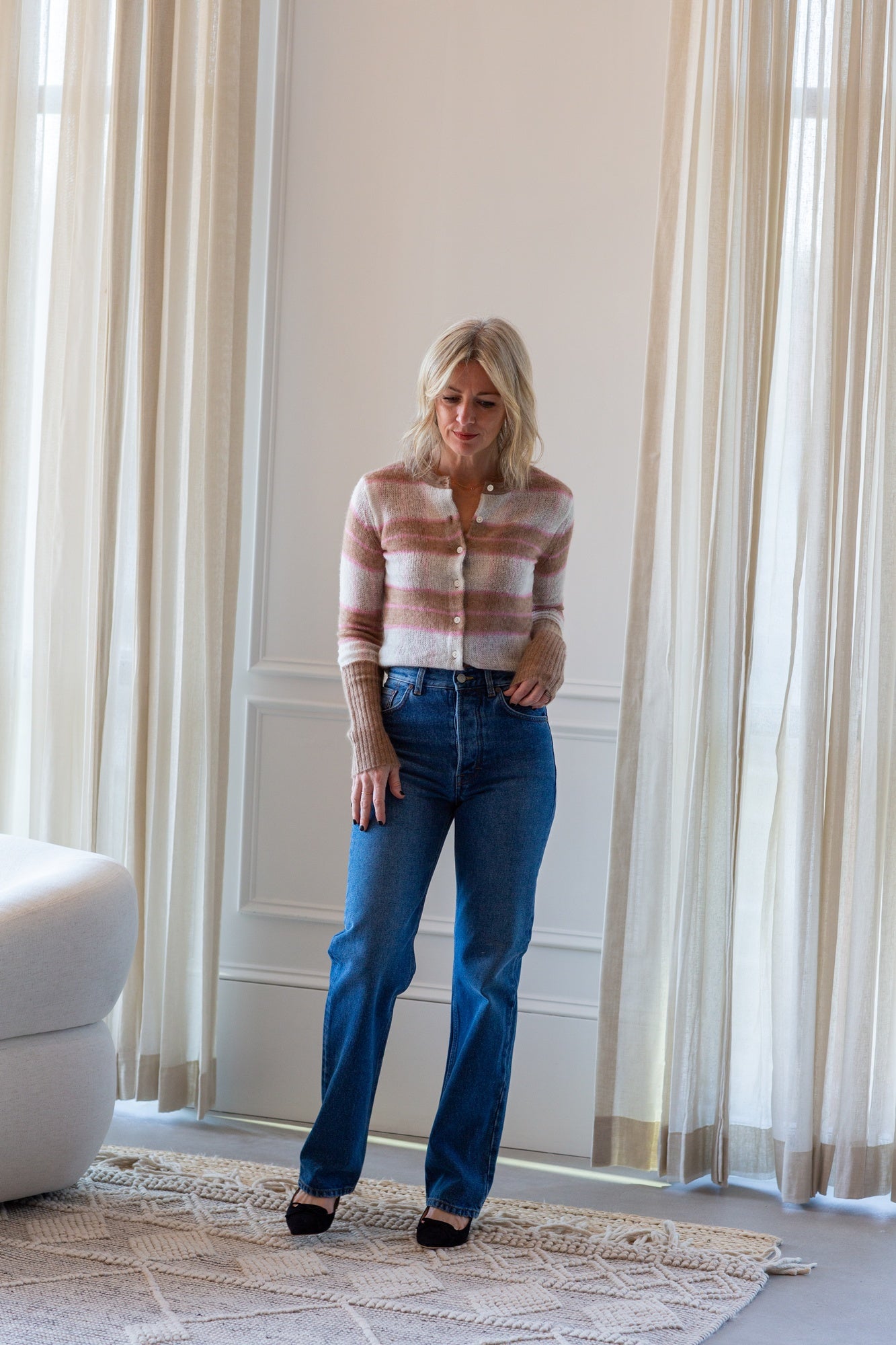 image of a model wearing the Guest in residence shadow plaid cardigan and house of dagmar jeans