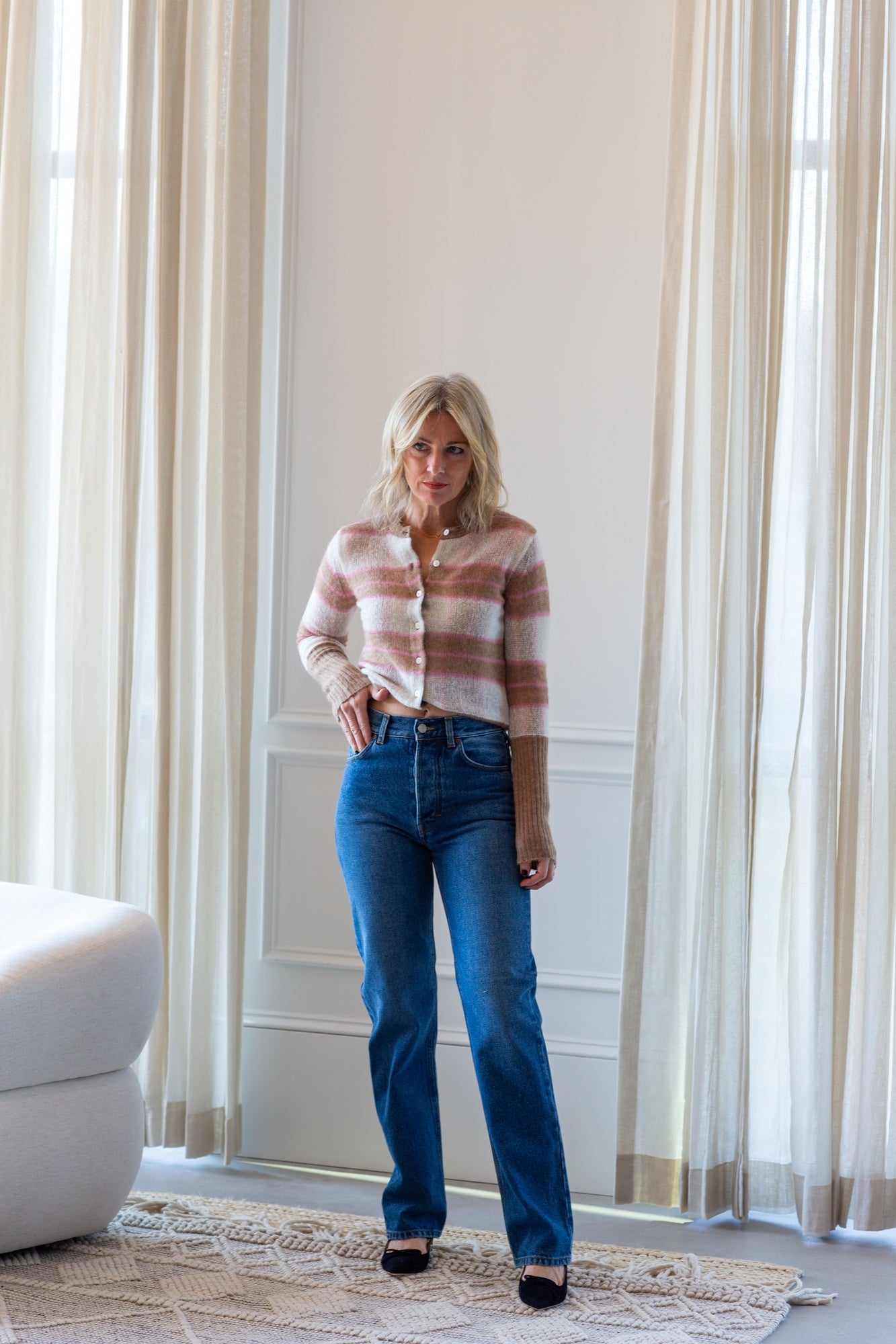 image of a model wearing the Guest in residence shadow plaid cardigan and house of dagmar jeans