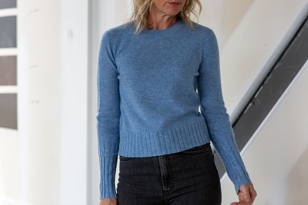 Person wearing a blue sweater in an indoor setting