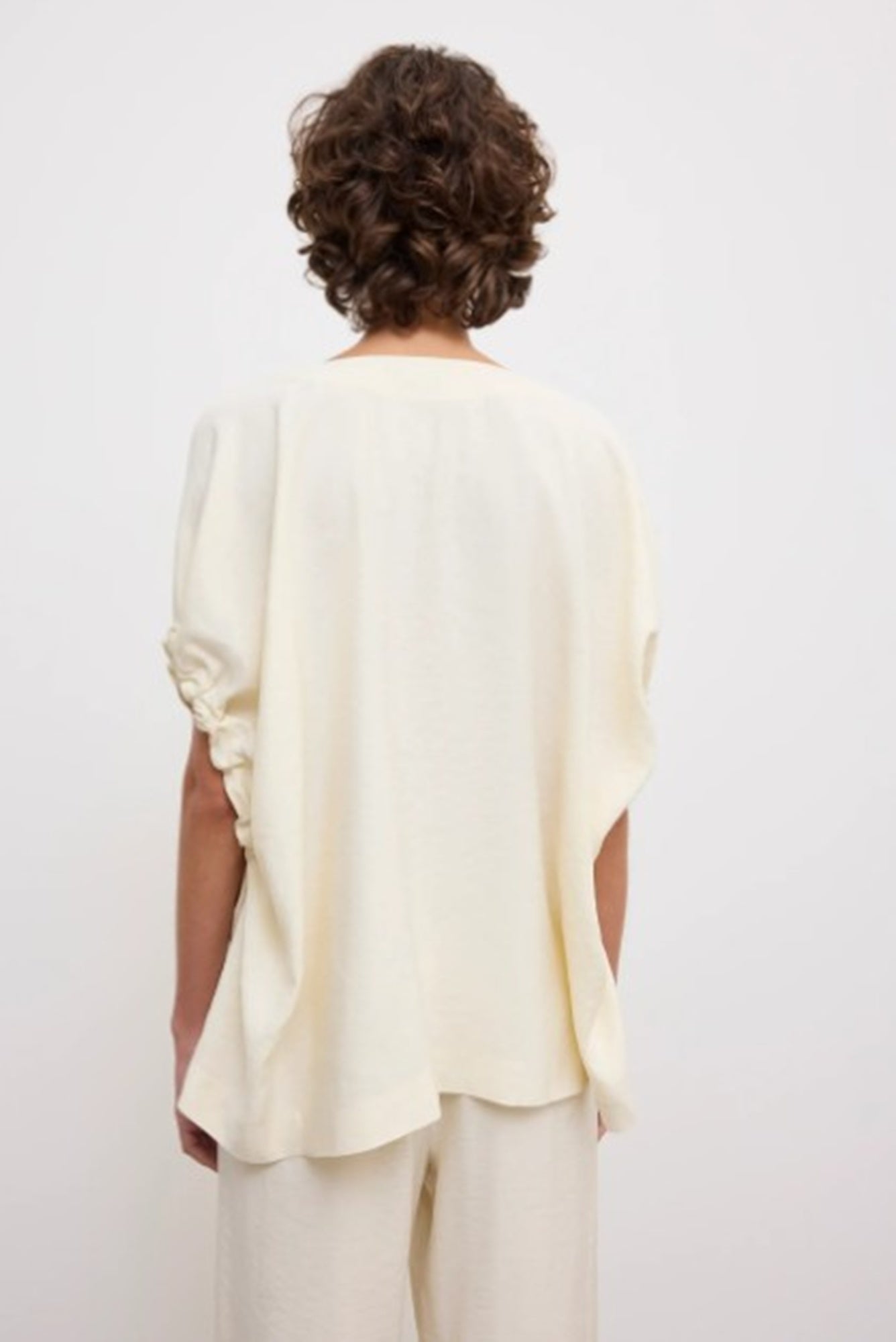 back image of a woman wearing the House of Dagmar Rouched V-Neck Top