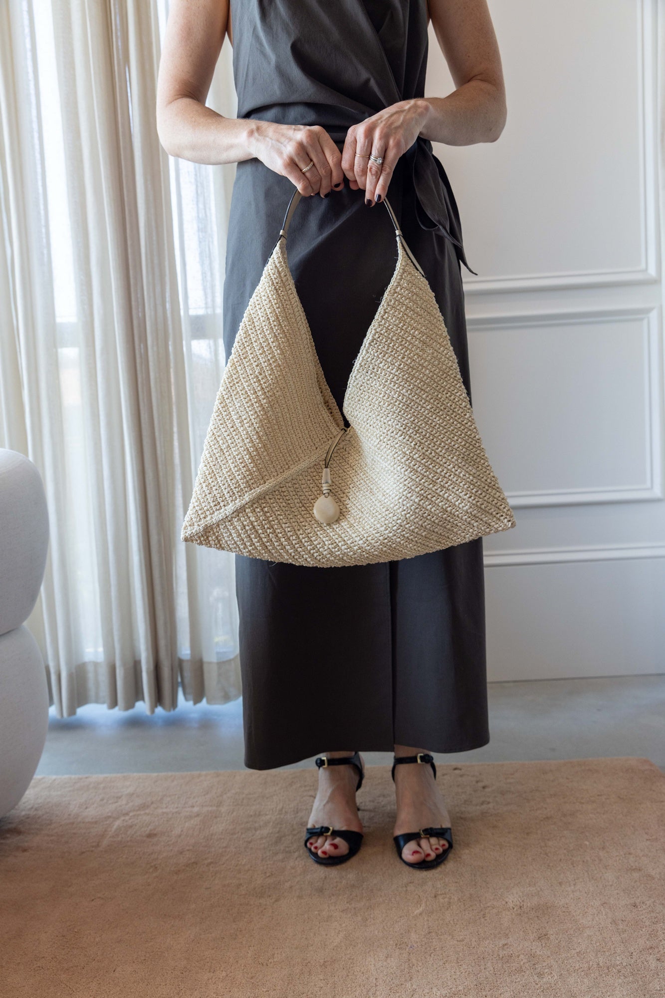 Woman wearing Hunting Season Large Origami Handbag against white curtains