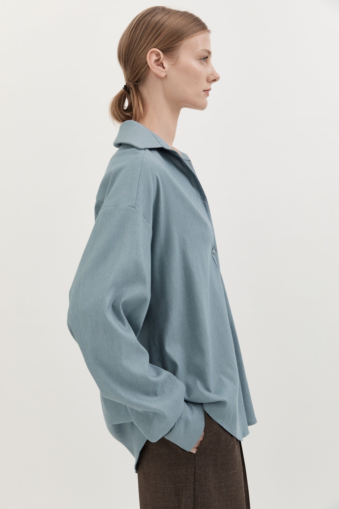 Woman wearing a light blue shirt against a plain background