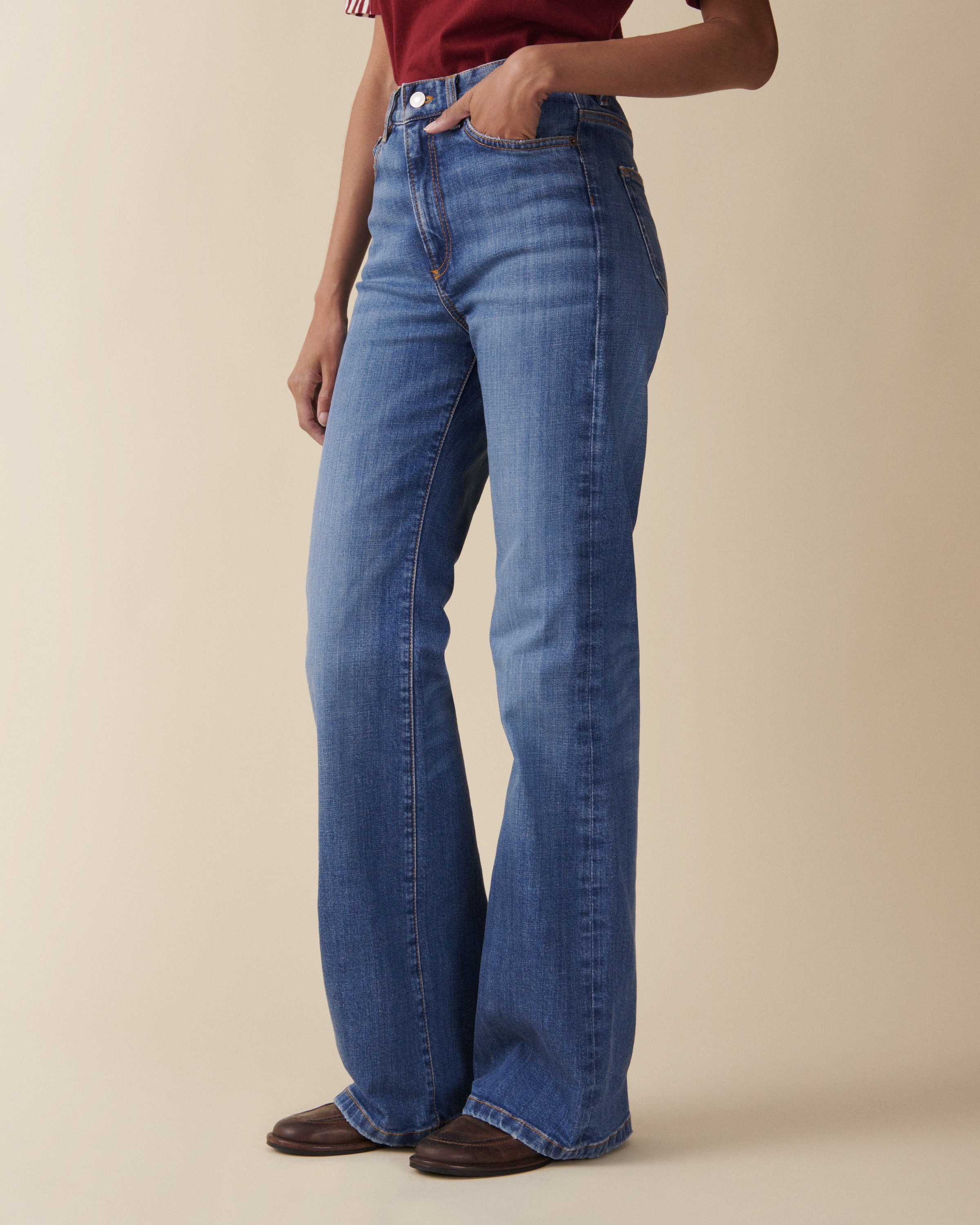Person wearing blue jeans on a beige background