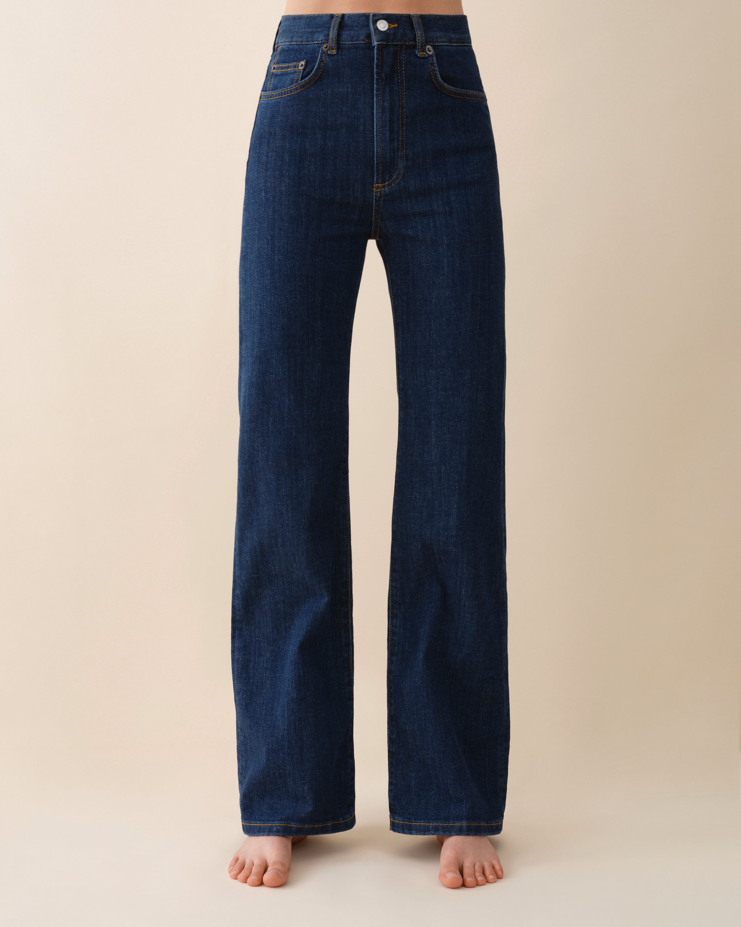 Dark blue jeans on a beige background