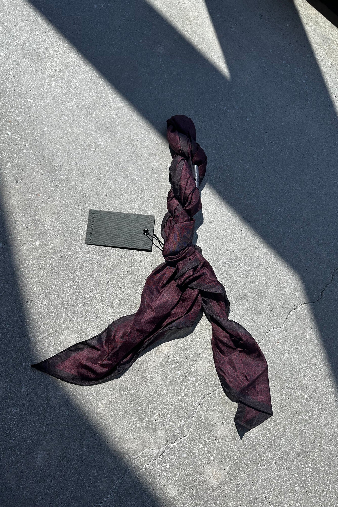 silk scarf laying on a concrete floor