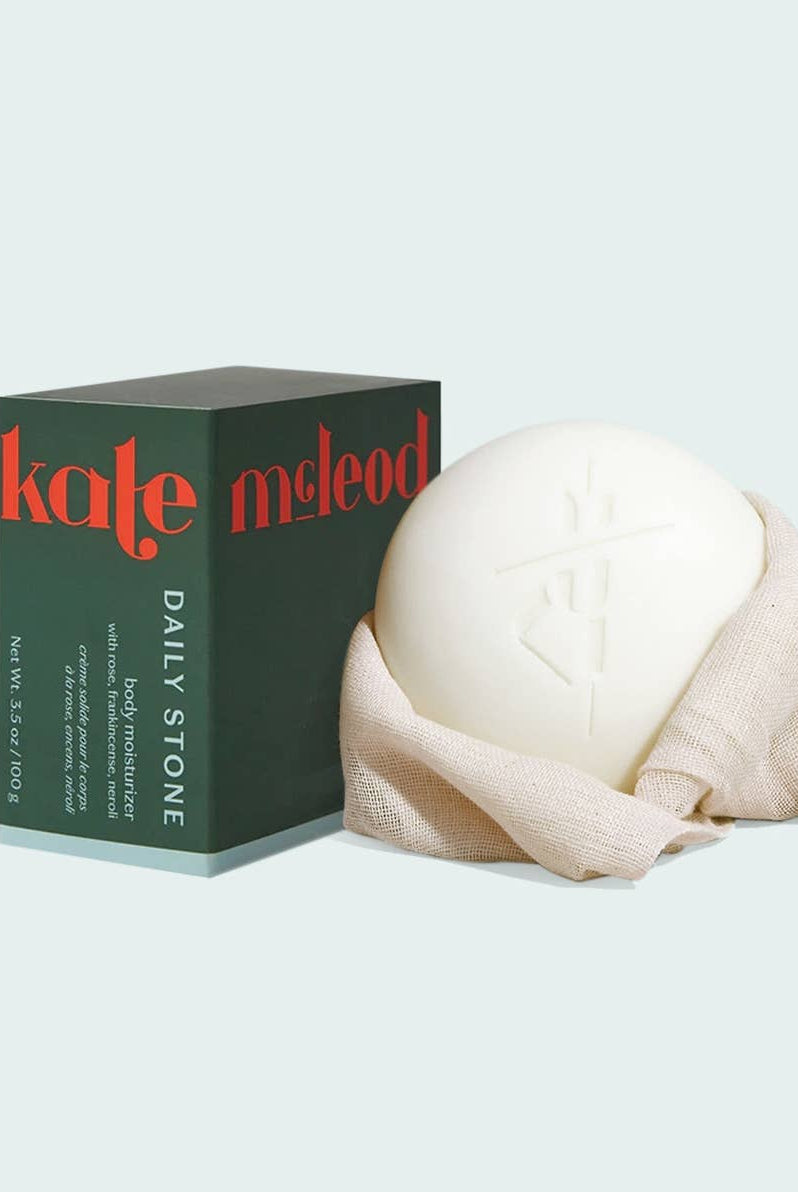 White stone wrapped in cloth next to a 'kate mcLeod' box on a light gray background