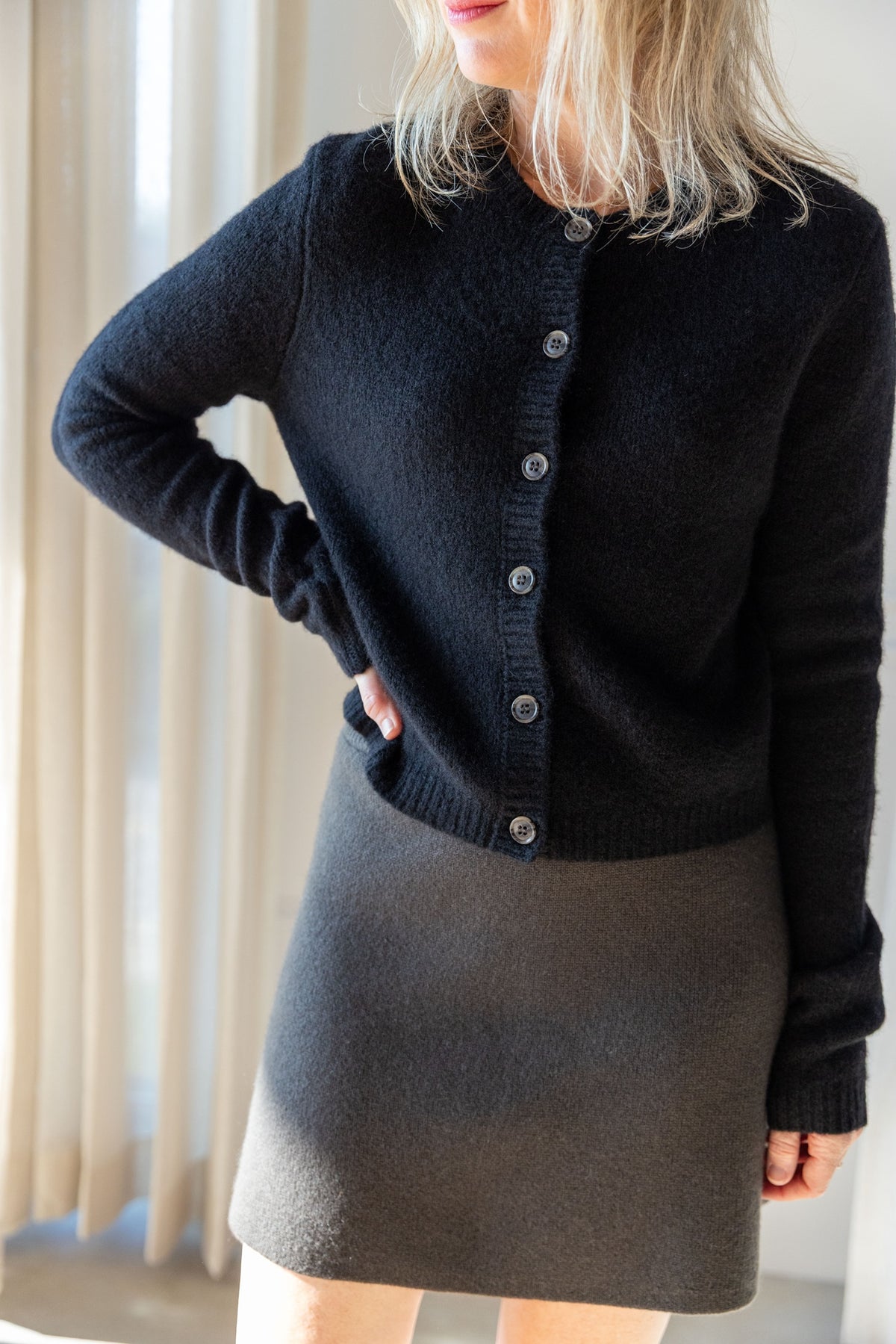 Lisa Yang Felicia Cardigan in noir silk cashmere, buttoned and styled with the Clare cashmere mini skirt