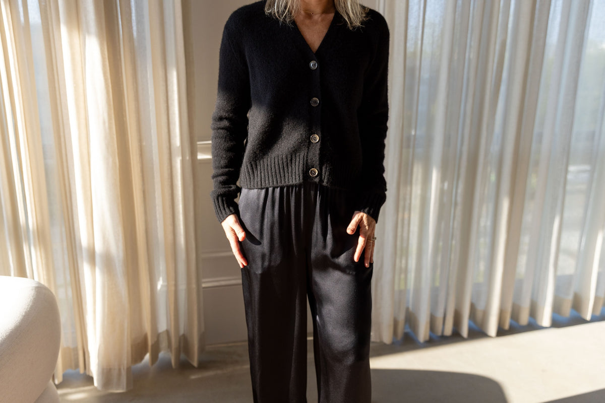 Lisa Yang Marionette Cardigan in black, buttoned and worn with Sablyn Brynn silk pants