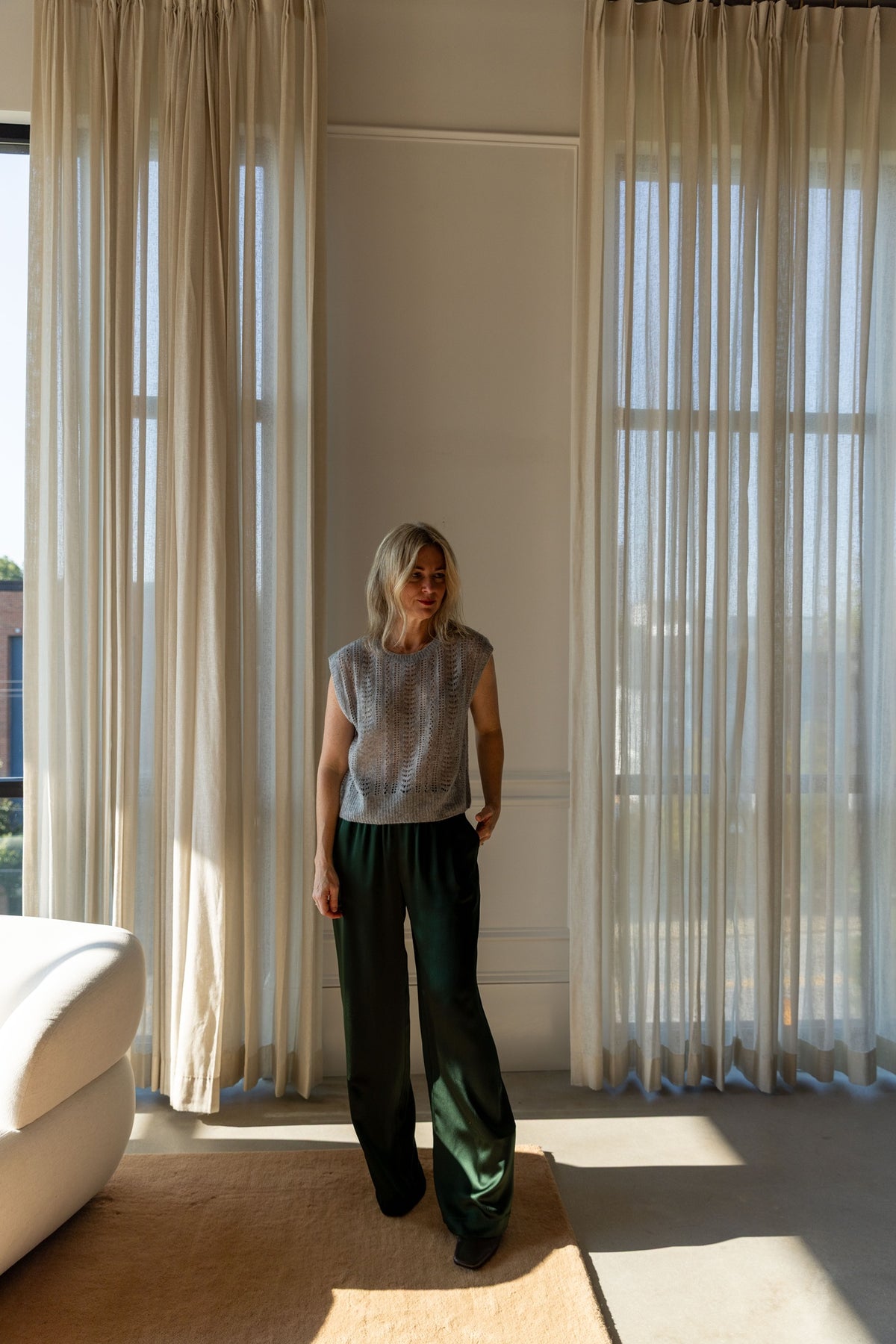 Lisa Yang Nian Vest in cloudy grey and Sablyn Brynn silk pants, full-length front view by the window