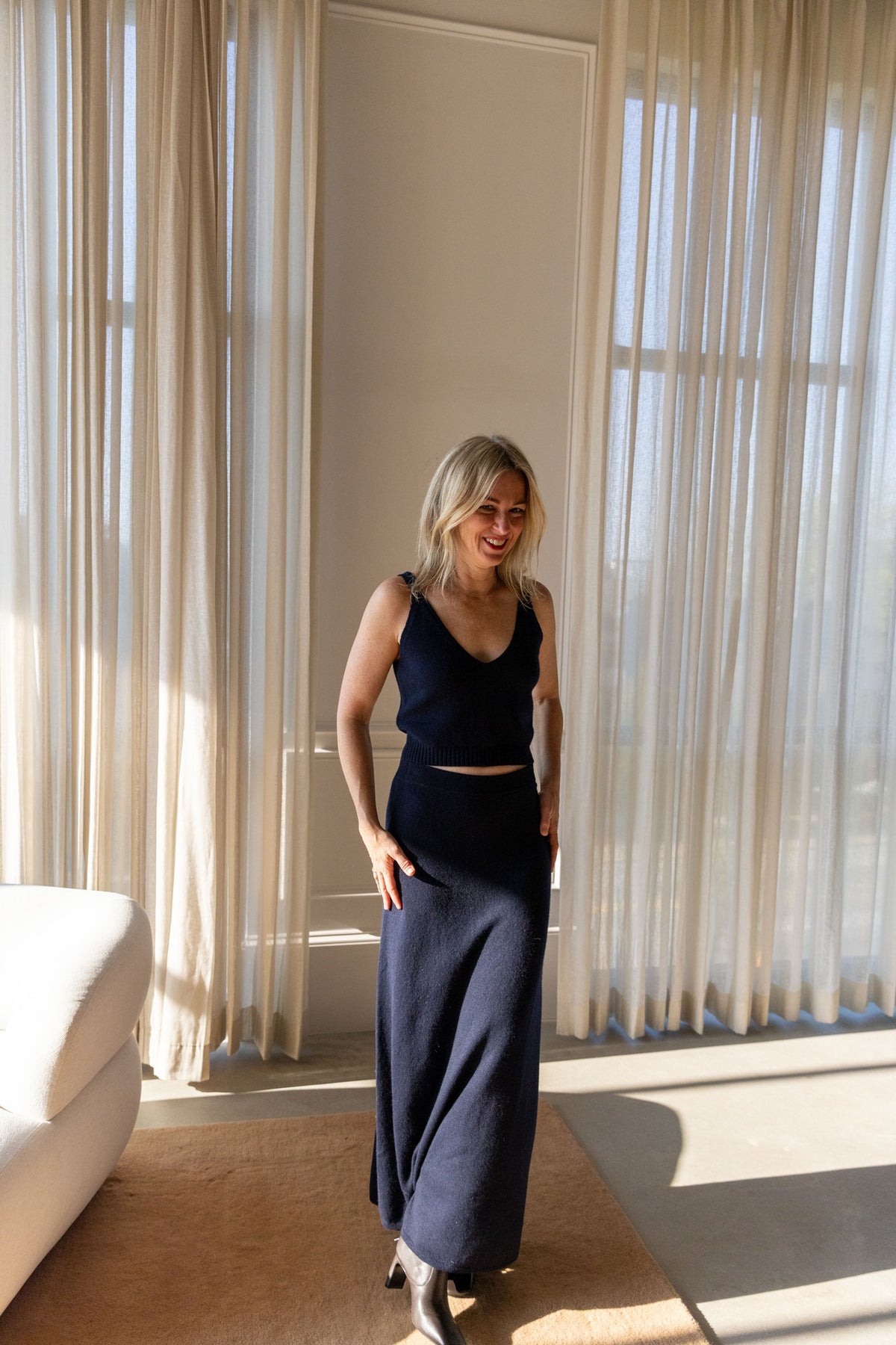 Lisa Yang Violia Top and Dolly Skirt in navy cashmere, full-length view in a sunlit room