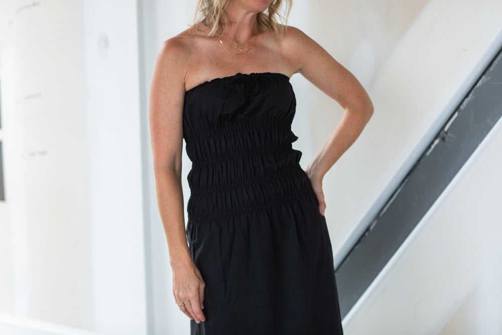 Woman wearing a black strapless dress in an indoor setting