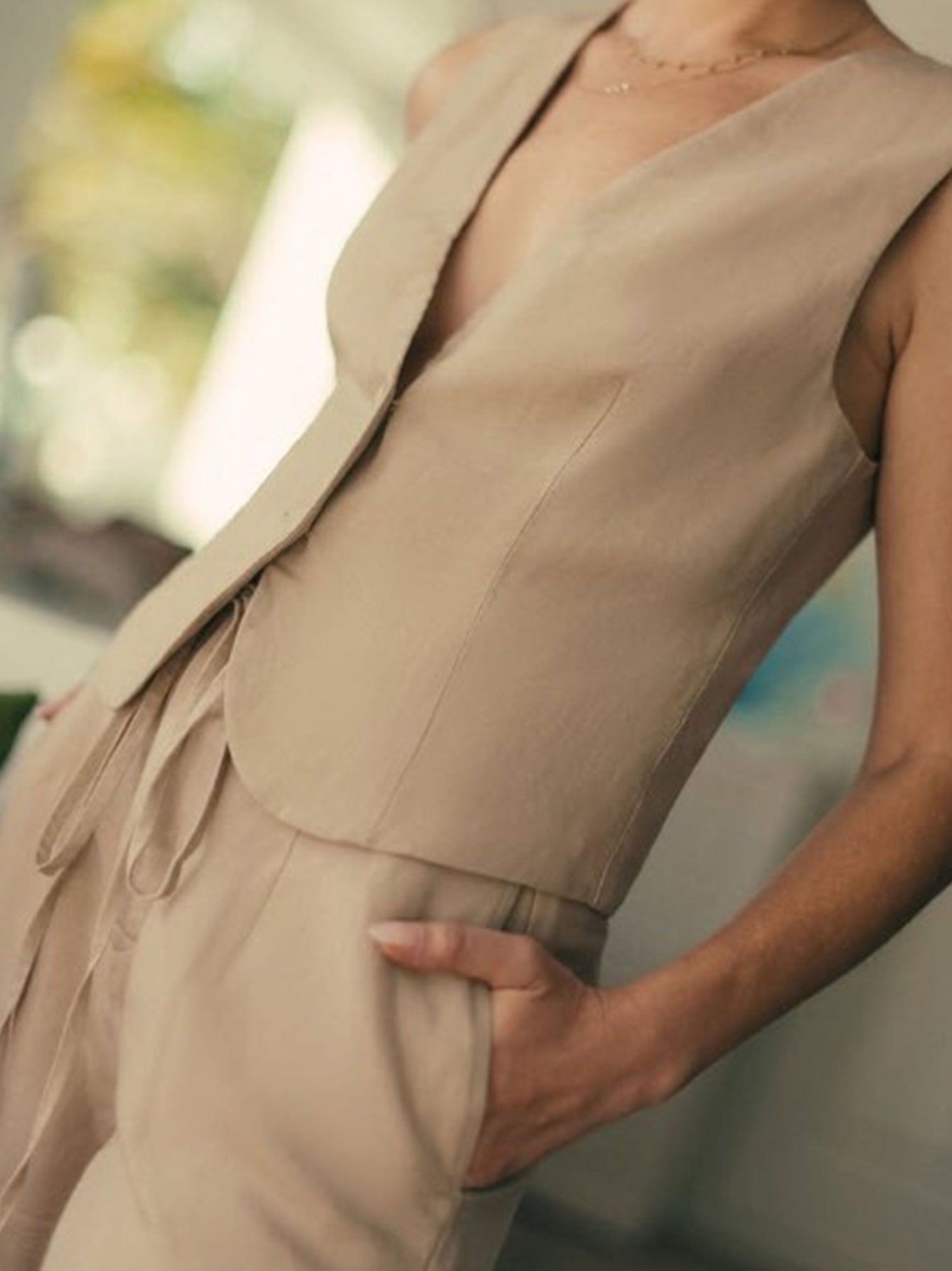 Beige sleeveless top worn by a person with a blurred background