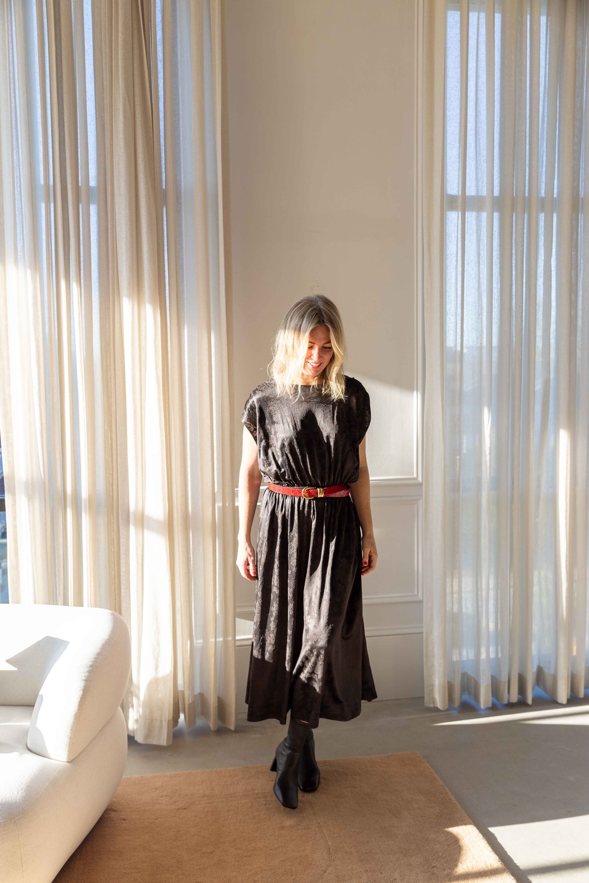 by Malene Birger Zoilo Belt in Red Dahlia over a dark jacquard dress with black boots, three-quarter view