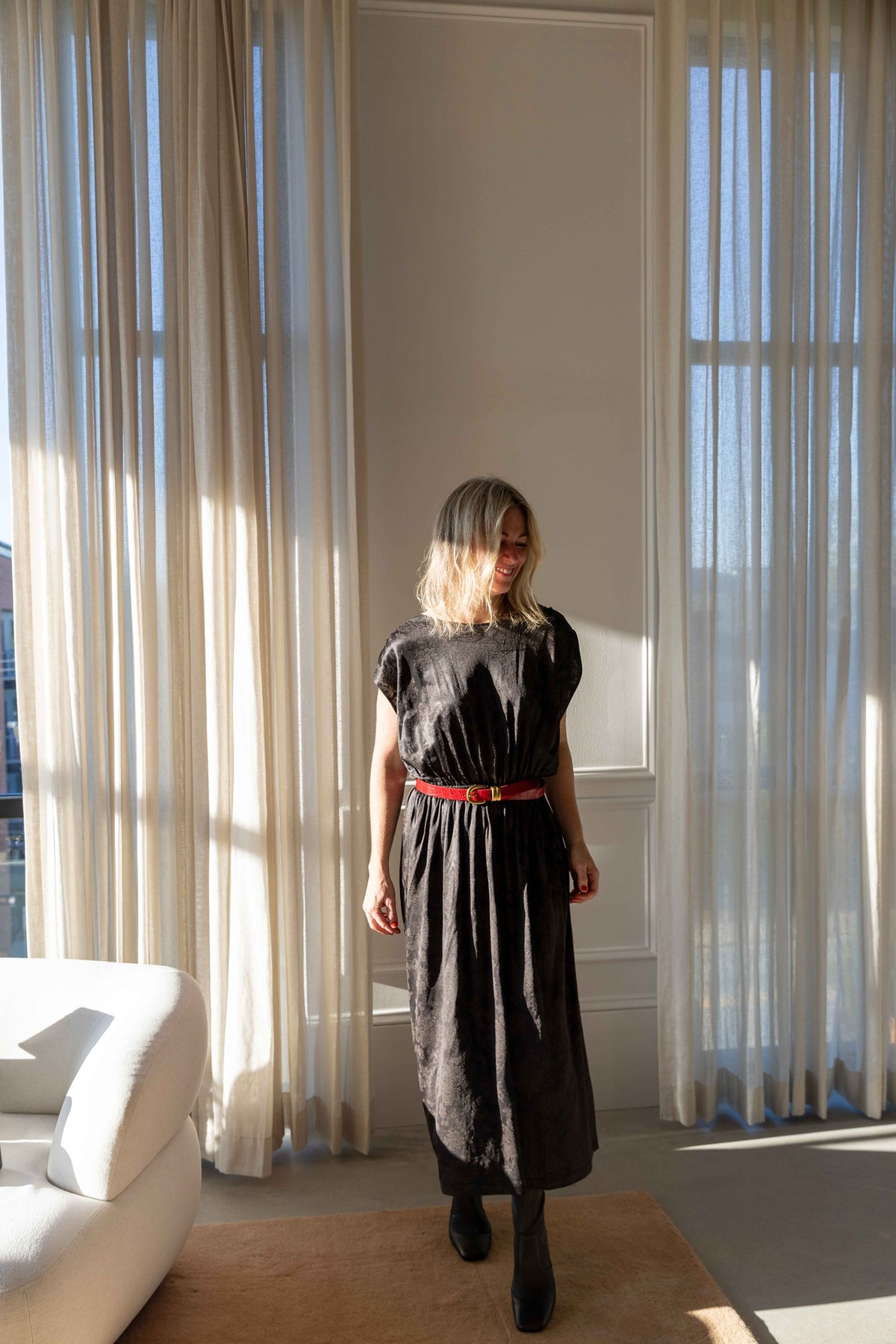 by Malene Birger Zoilo Belt in Red Dahlia worn at the waist of a dark midi dress with boots, full-length view