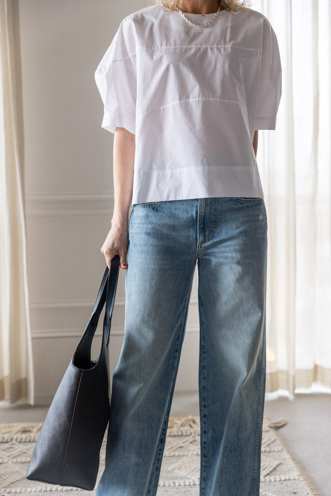 image of a woman wearing the Rachel Comey Rugby Top and Amo Kira Jeans with an Aesther Ekme Handbag