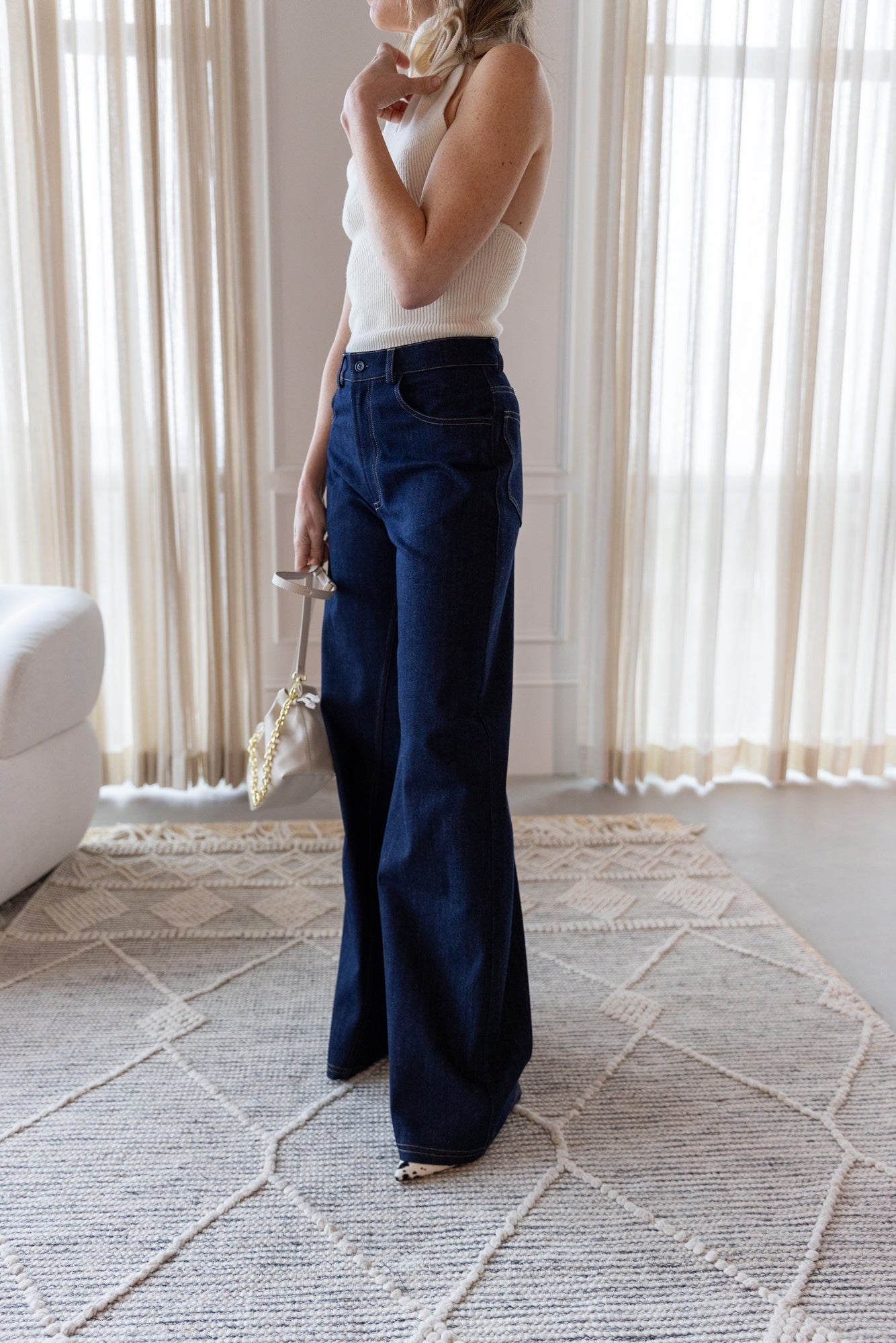 image of a woman wearing the Rhune Estelle Knit Top and Feline Denim