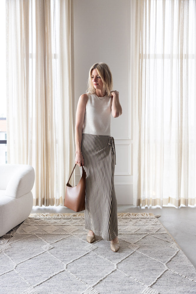 image of a woman wearing the Sablyn Aja Tank and Alysi Striped Skirt with the Aesther Ekme Demi Lune Bag