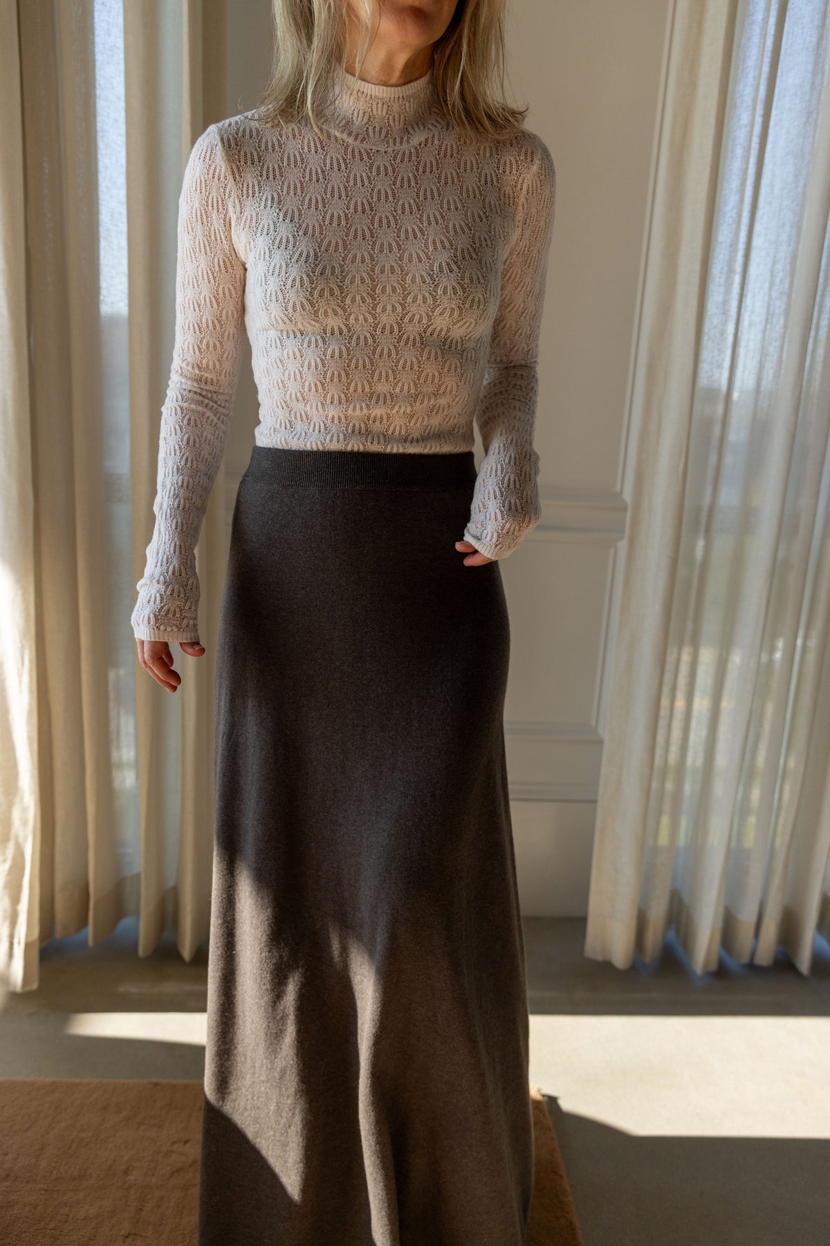 Sablyn Rhea turtleneck in sheer ivory knit tucked into the Lisa Yang Adrienne Skirt in deep walnut