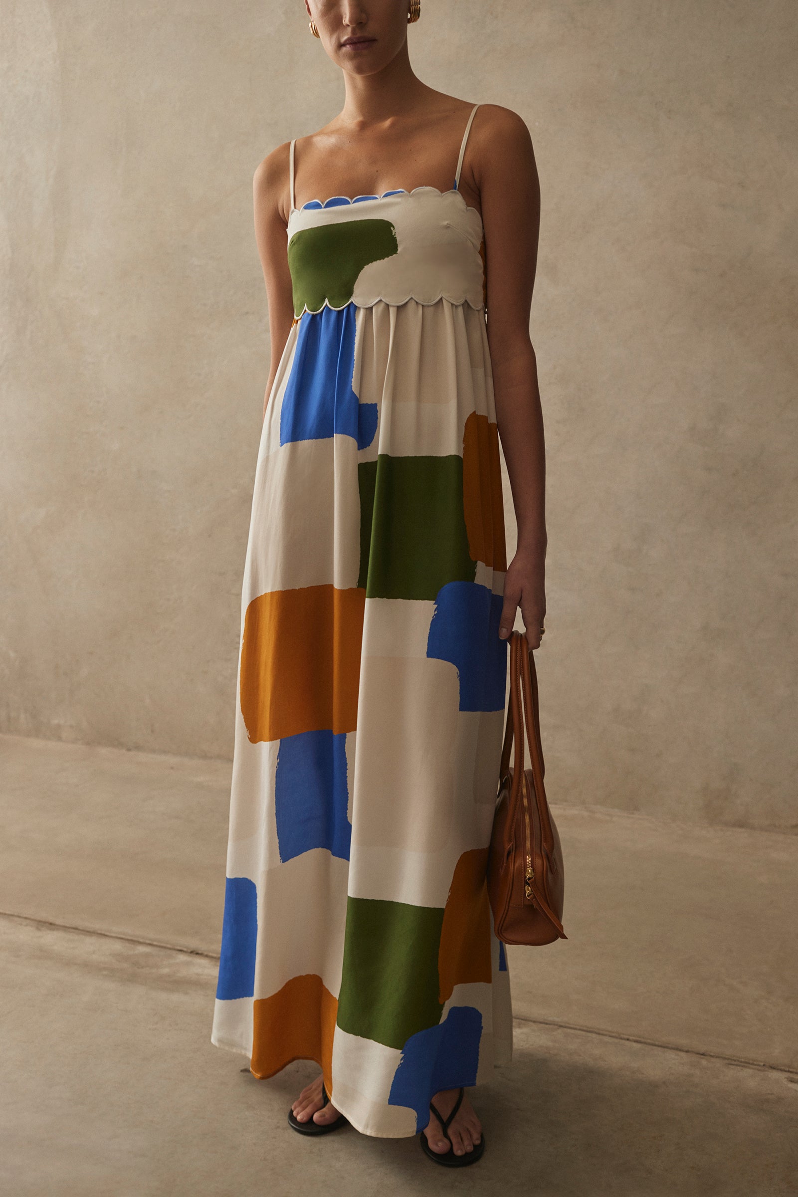 Woman wearing a colorful geometric-patterned dress against a neutral background