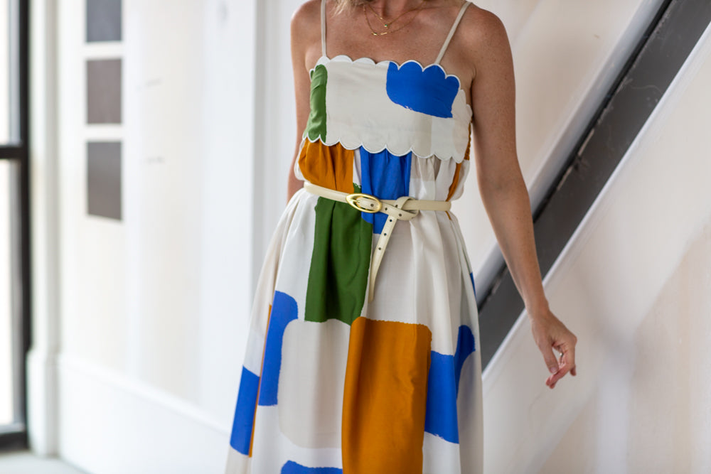 Woman wearing a colorful dress with a belt in an indoor setting