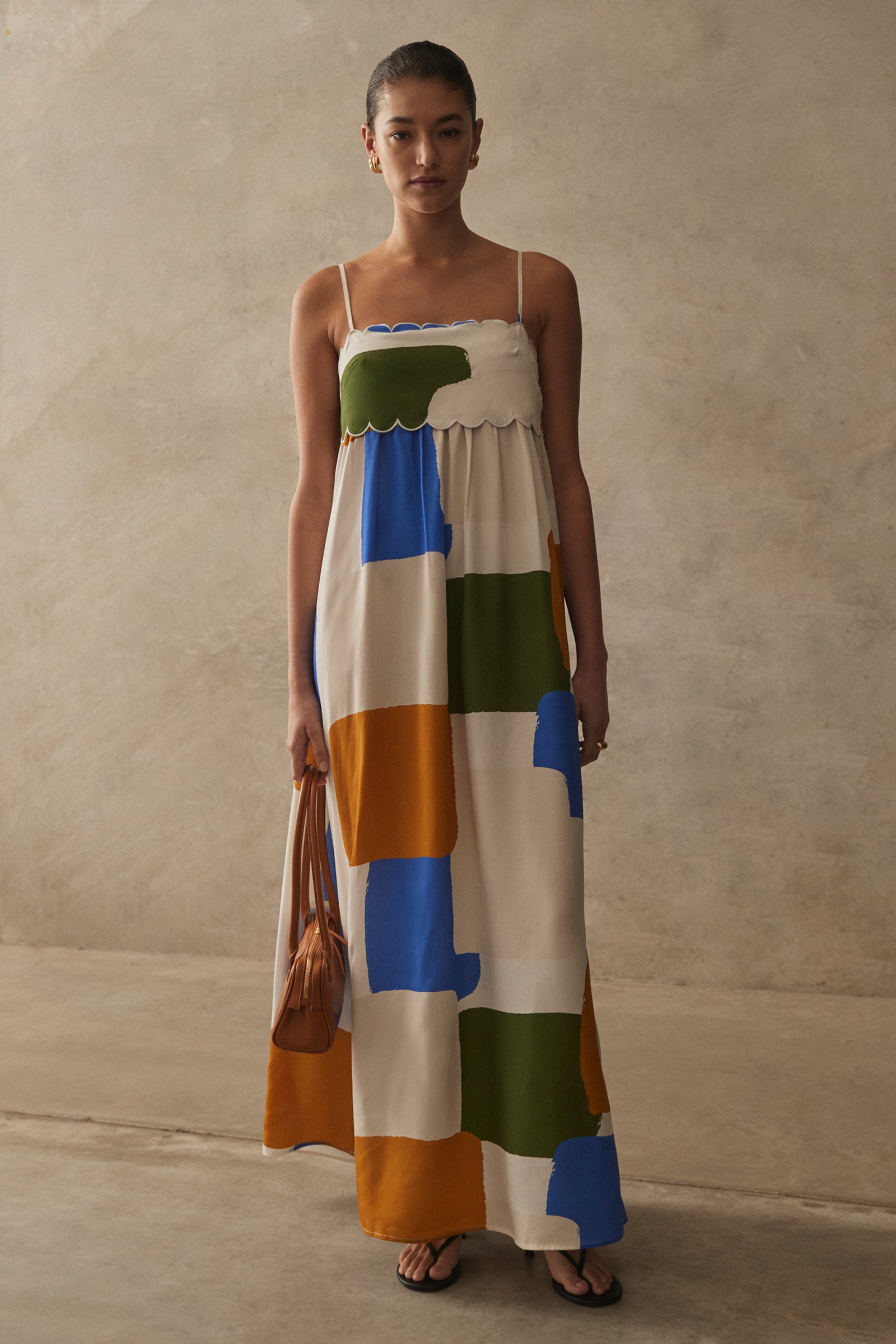 Woman wearing a colorful dress with abstract patterns against a plain background