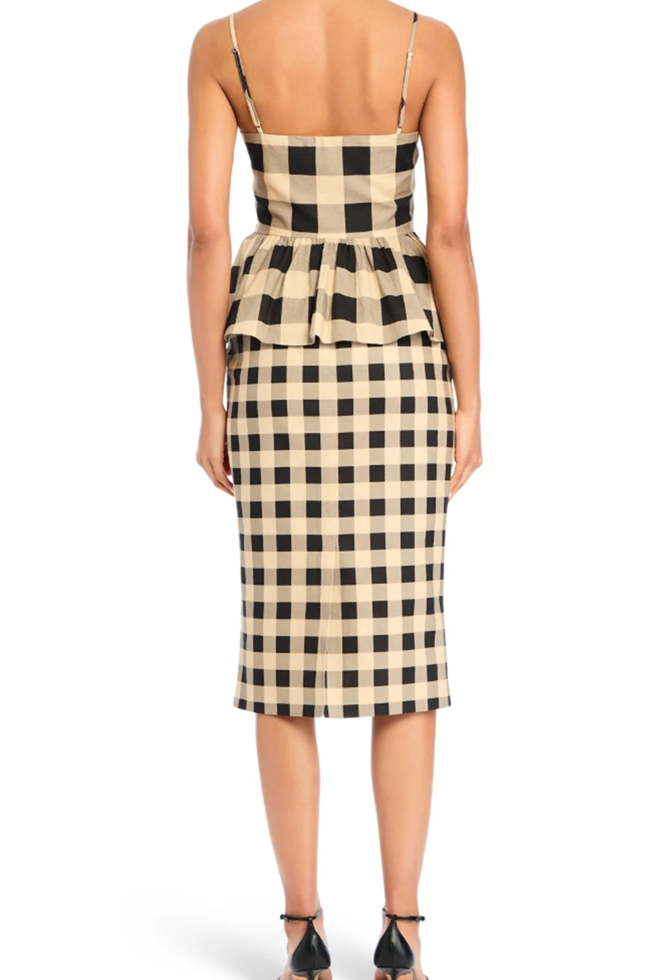 Woman wearing a black and beige checkered top and skirt on a white background