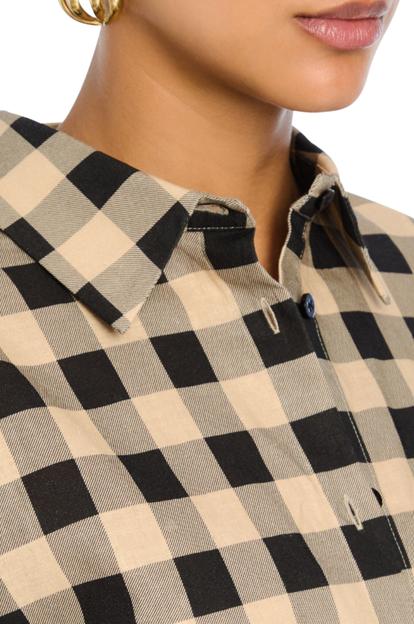 Close-up of a person wearing a black and beige checkered shirt.