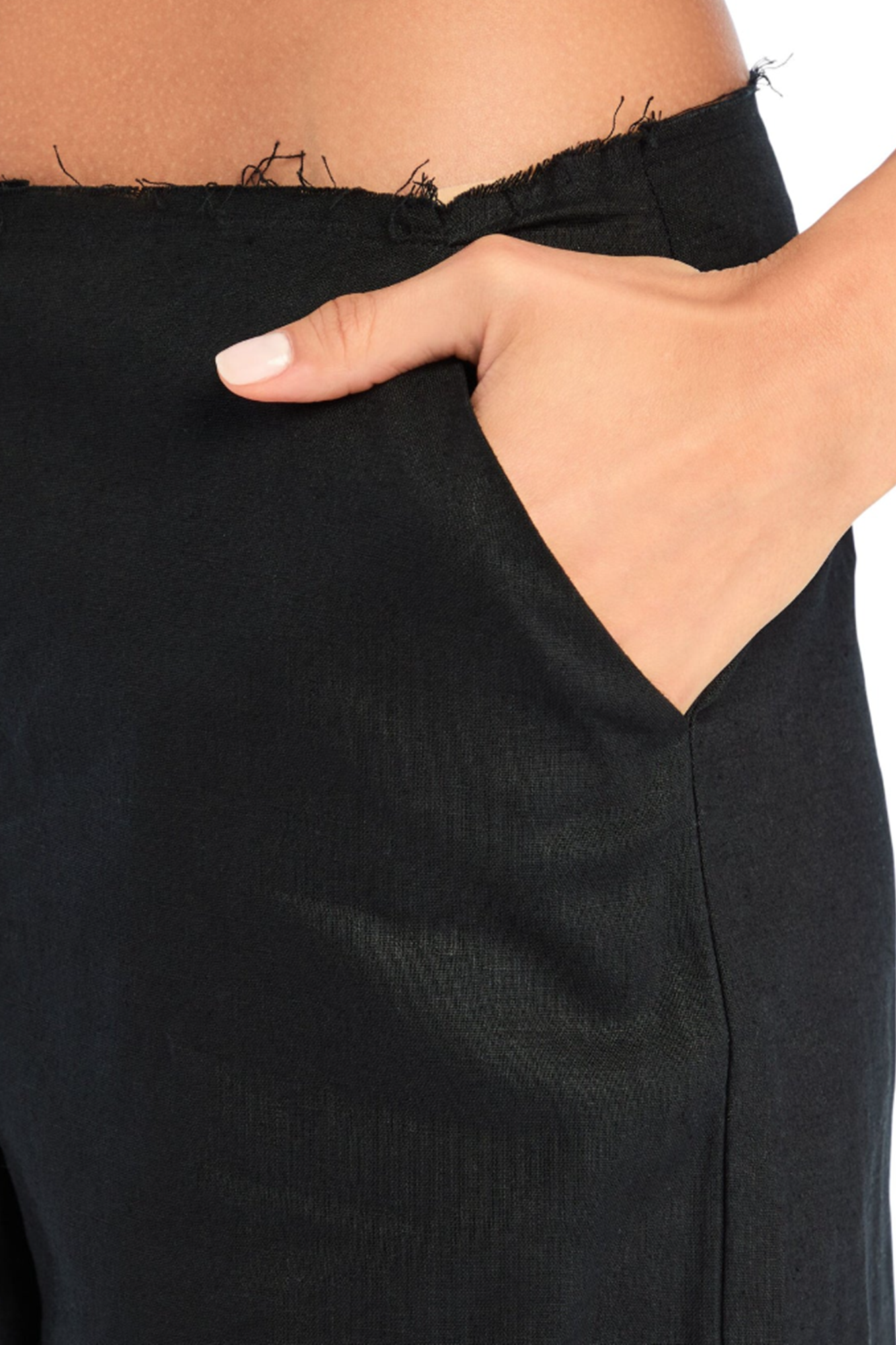 Close-up of a person wearing black pants with a hand adjusting the waistband.