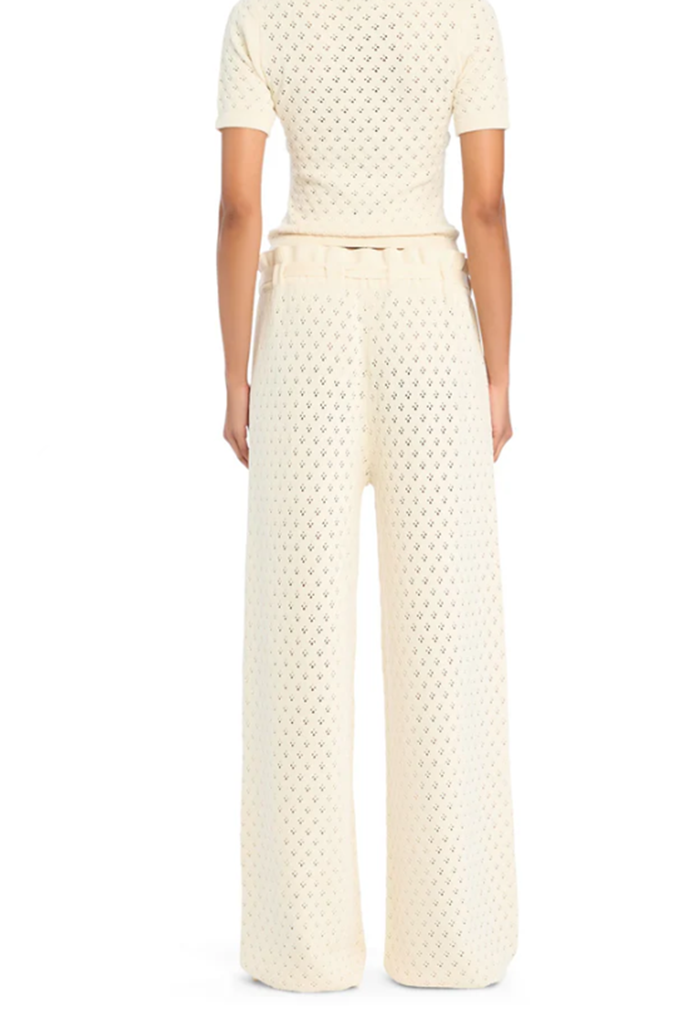 Person wearing a textured knit white outfit on a white background