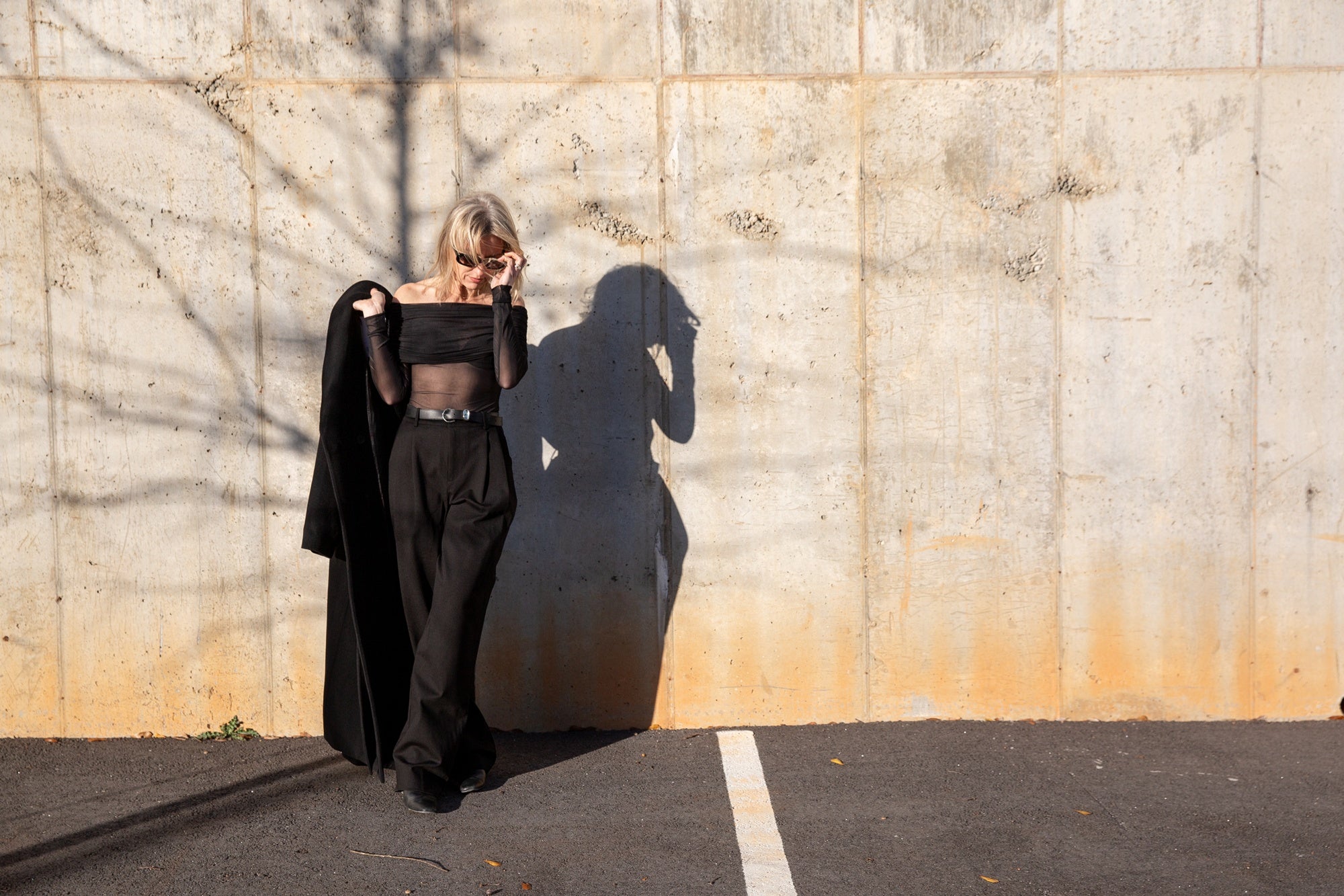 image of a woman wearing the seroya rosa top and sonya pants with the house of dagmar coat