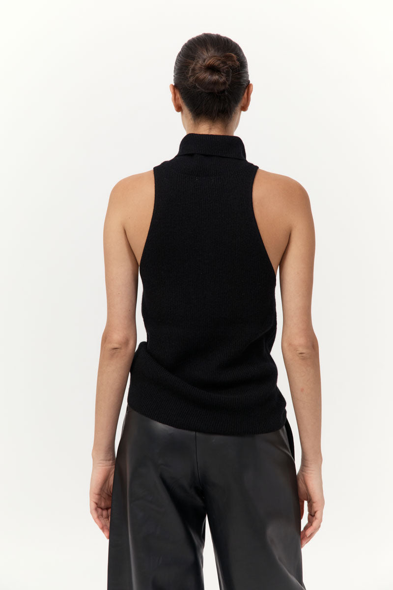 Person wearing a black sleeveless top and pants on a white background