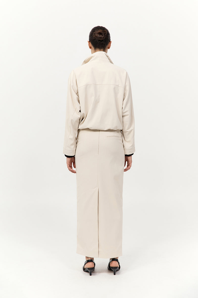 Person wearing a beige outfit on a white background