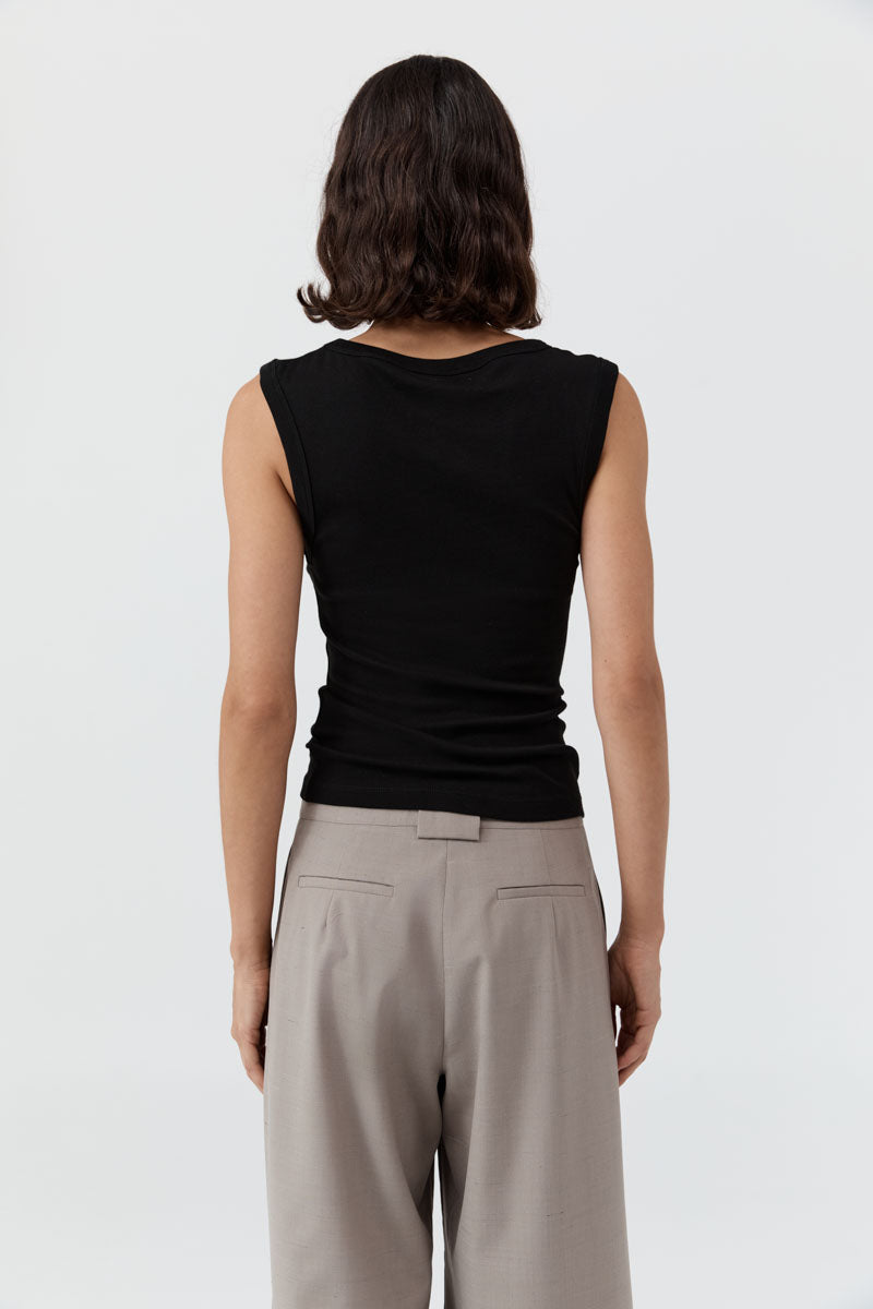 image of a woman wearing the st agni organic cotton 90s tank in black