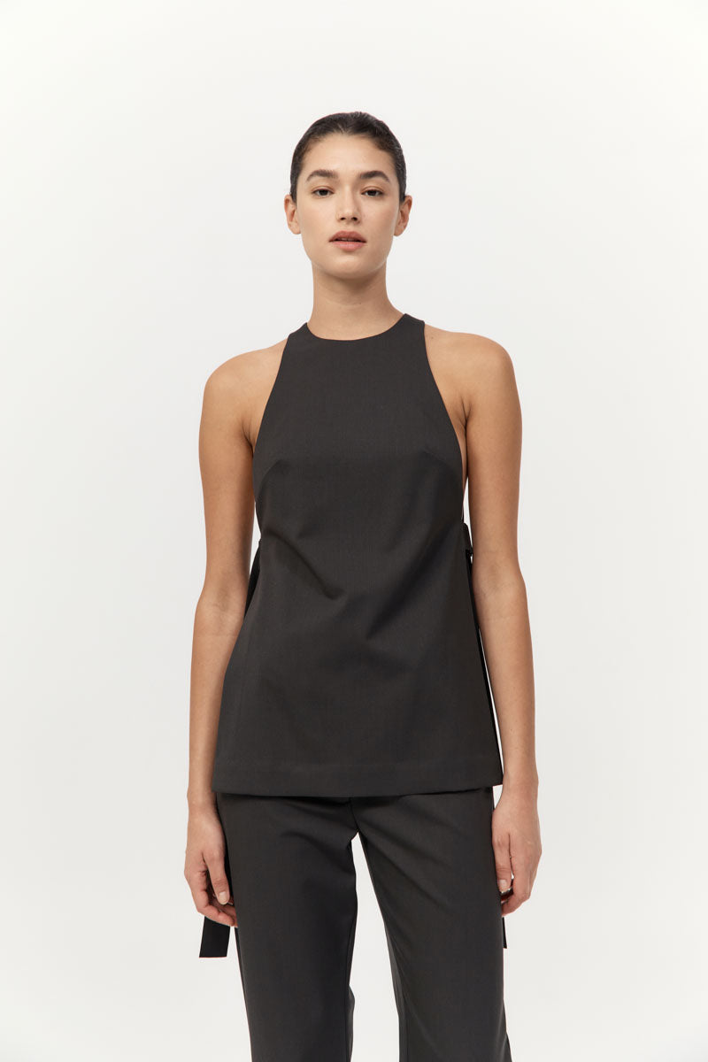 Person wearing a black sleeveless top and pants on a white background
