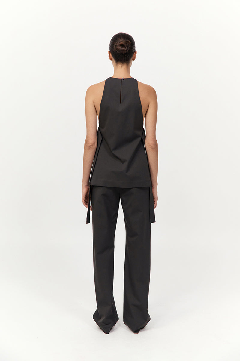Person wearing a black sleeveless top and pants on a white background