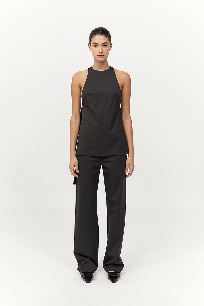 Person wearing a black sleeveless top and pants on a white background