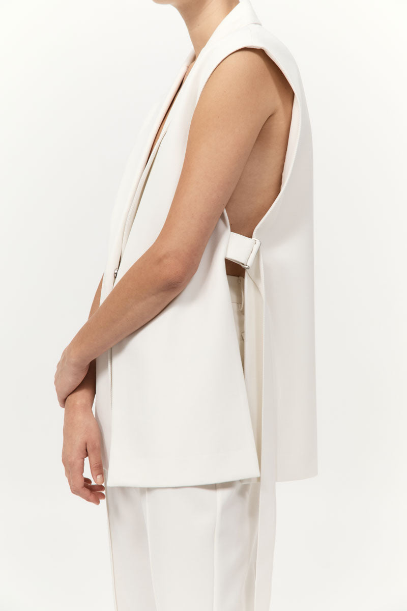 White sleeveless top worn by a person on a plain background