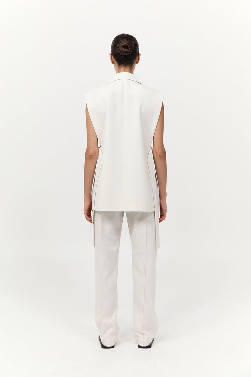 Person wearing a white sleeveless top and pants on a white background