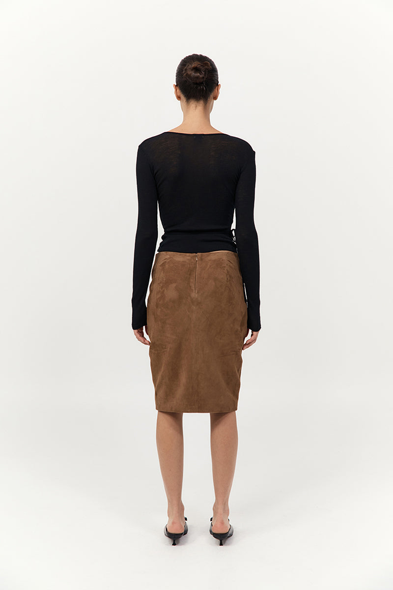 Person wearing a black top and brown skirt on a white background